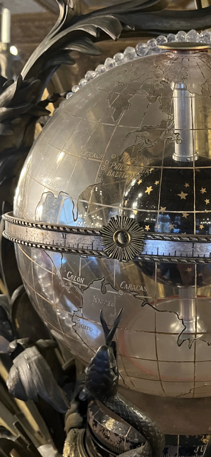Close view showing etched city names, graticule lines, Roman numerals, and the dark celestial center