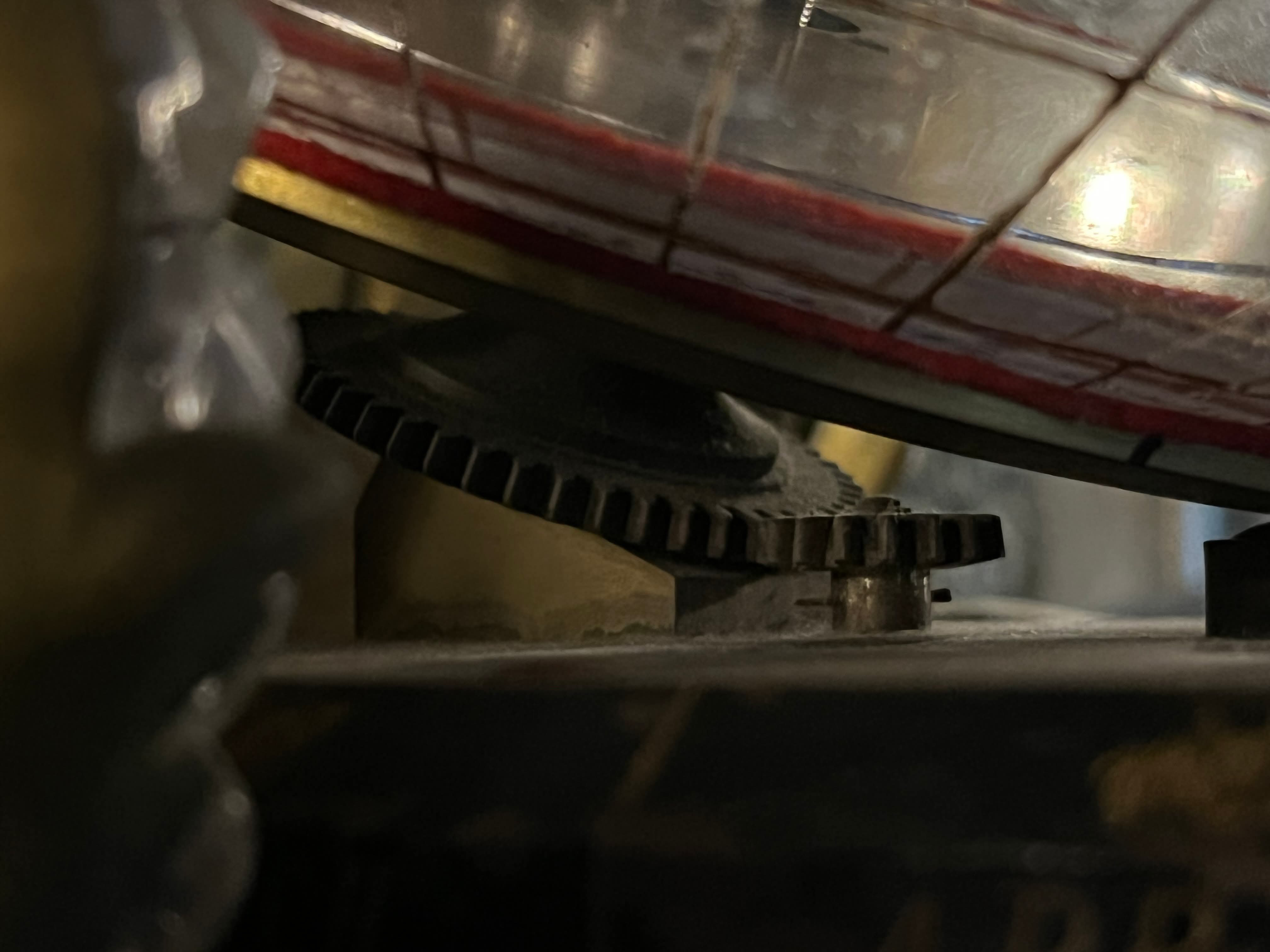 Gear detail beneath the globe, consistent with a key-driven or clockwork rotational system